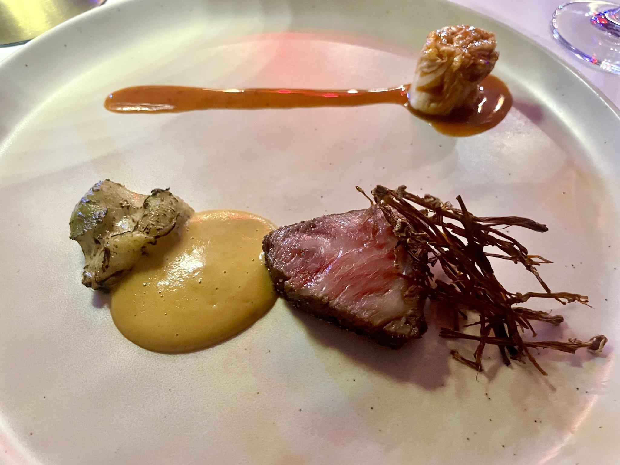 Sauteed A5 Wagyu Beef, Spicy Chinese Mustard Sauce, Char-Poached Artichoke Heart, Unfermented Kim Chi & Jus, and delicately Char-Dried Enoki Mushrooms. Image by Emily Simpson.