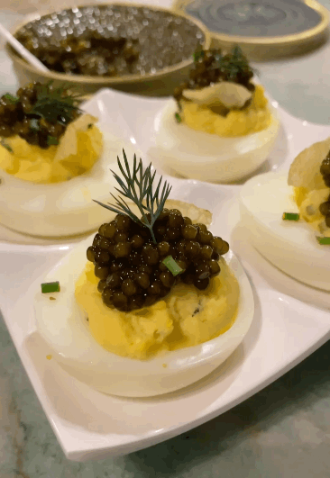 Truffle Deviled Eggs with Kaluga Caviar from The Caviar Co., Crème Fraîche, and Kettle Chips. Video by Christianne Klein
