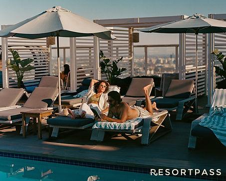 Two people lounge by a rooftop pool under umbrellas, with city skyline behind and RESORTPASS text at bottom.