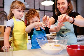 woman with two kids making dough