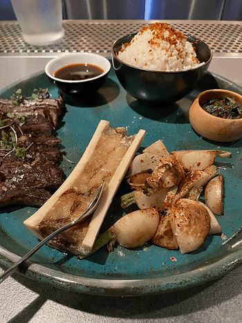 Wagyu Kalbi Short Rib – Roasted bone marrow, garlic rice, seasonal vegetables, “kudeesh”  finadene