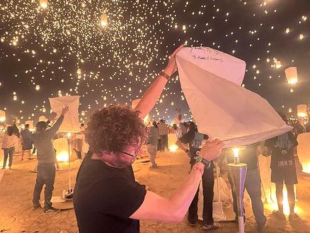 Lighting one of the lanterns at Rise Festival.  Image by Christianne Klein.