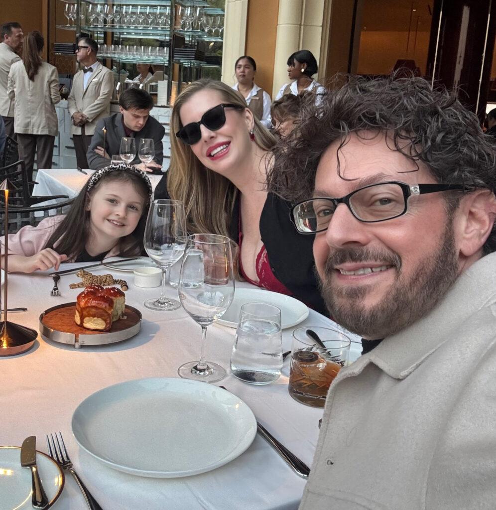 Christianne, Dan, and Livi enjoying a fabulous meal by the Lake of Dreams during their travels. Image by Dan Sattel.