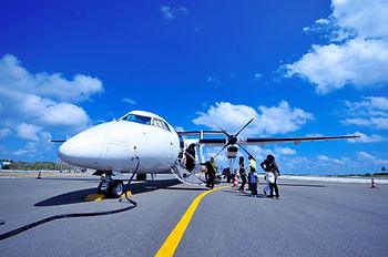 White plane on tarmac with passengers boarding. Labor Day 2024 is expected to bring vacationers all around the globe.  Image by Asad Photo Maldives.  